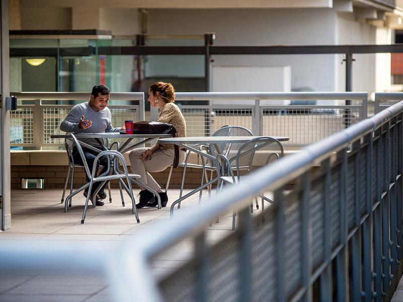 A guy talks to another student on campus. A guy talks to another student on campus.